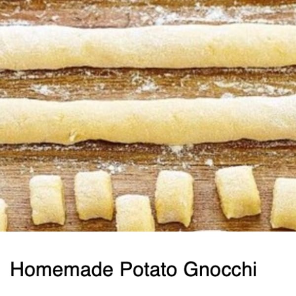 Rows of homemade potato gnocchi dough, some rolled into logs and some cut into pieces.