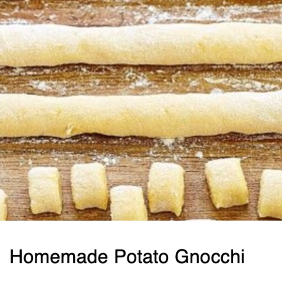 Rows of homemade potato gnocchi dough, some rolled into logs and some cut into pieces.