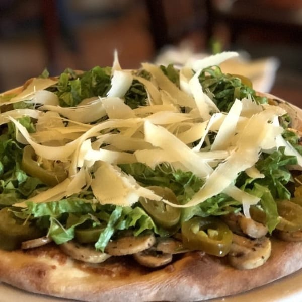 Michelangelo Ristorante's Italian pizza topped with fresh greens, mushrooms, jalapeños, and shaved Parmesan.
