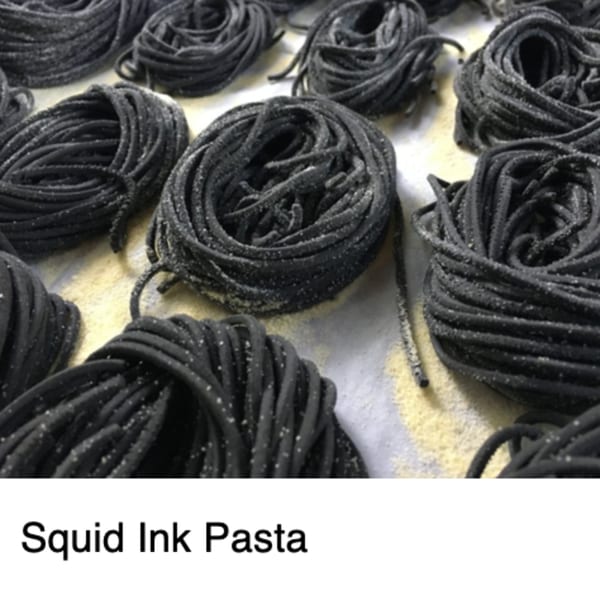 Coiled black squid ink pasta dusted with flour, ready for cooking at Michelangelo Ristorante.